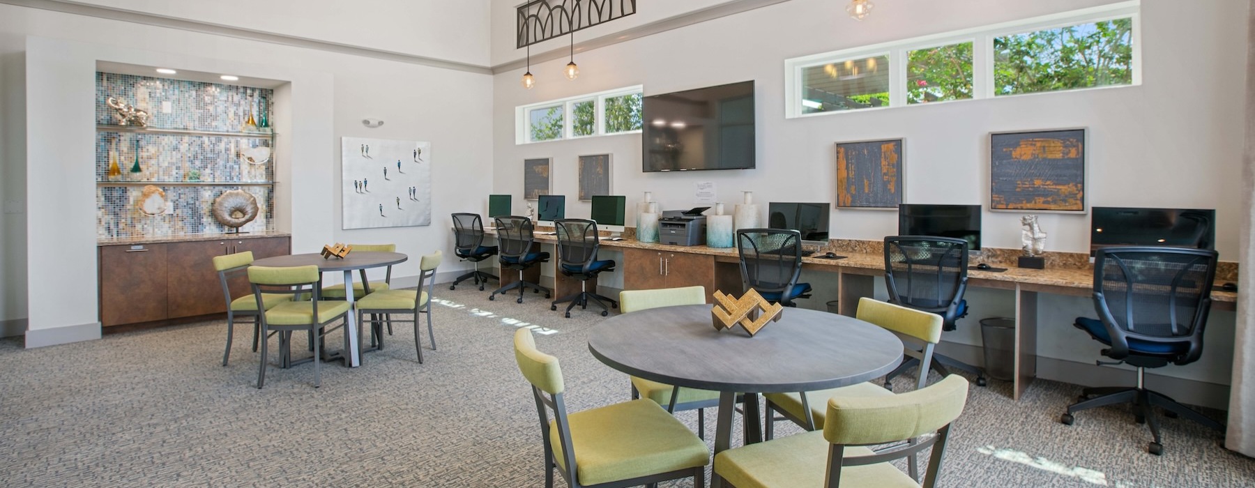 a co-working room with computers, tables and chairs