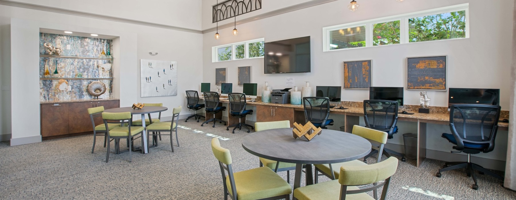 a co-working room with computers, tables and chairs